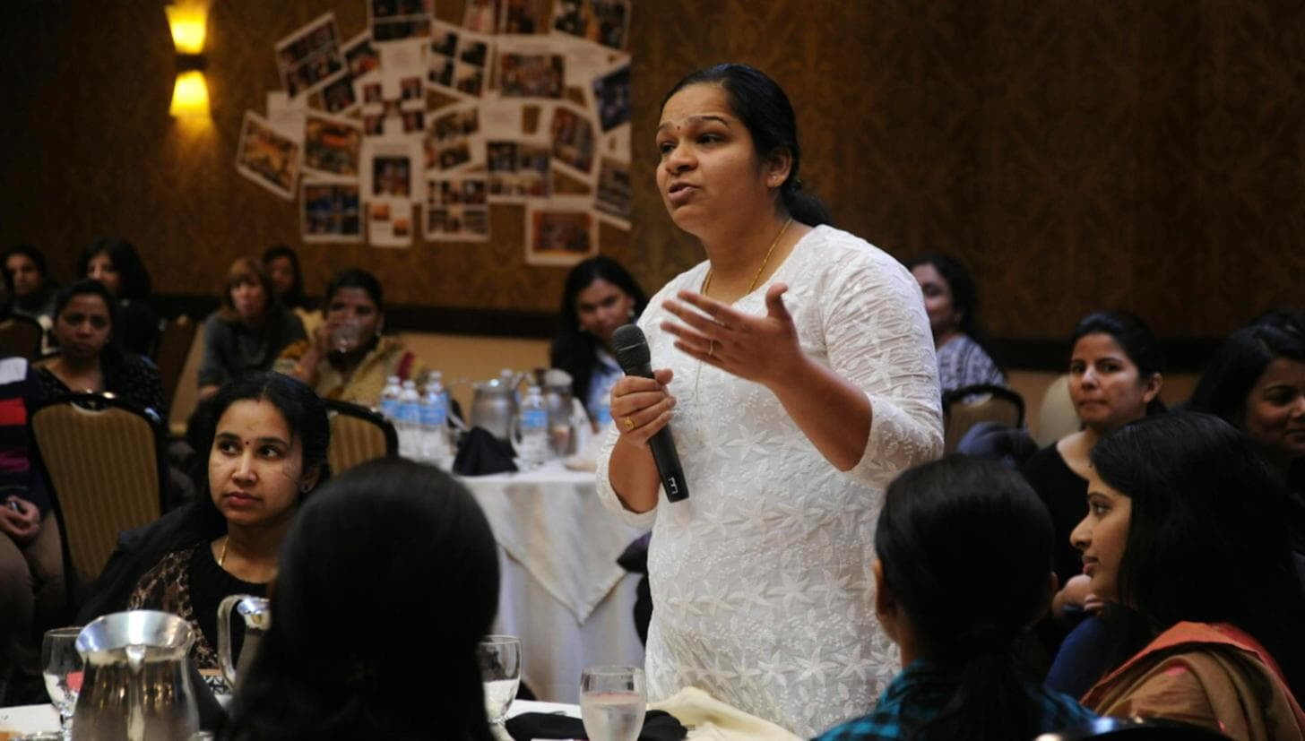 A facilitator speaking with participants during a classroom workshop